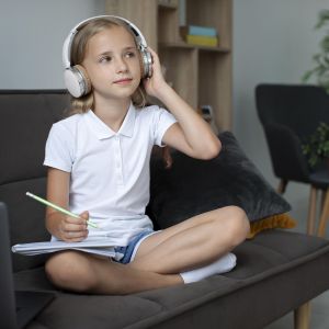 little-girl-participating-online-classes-while-using-headphones